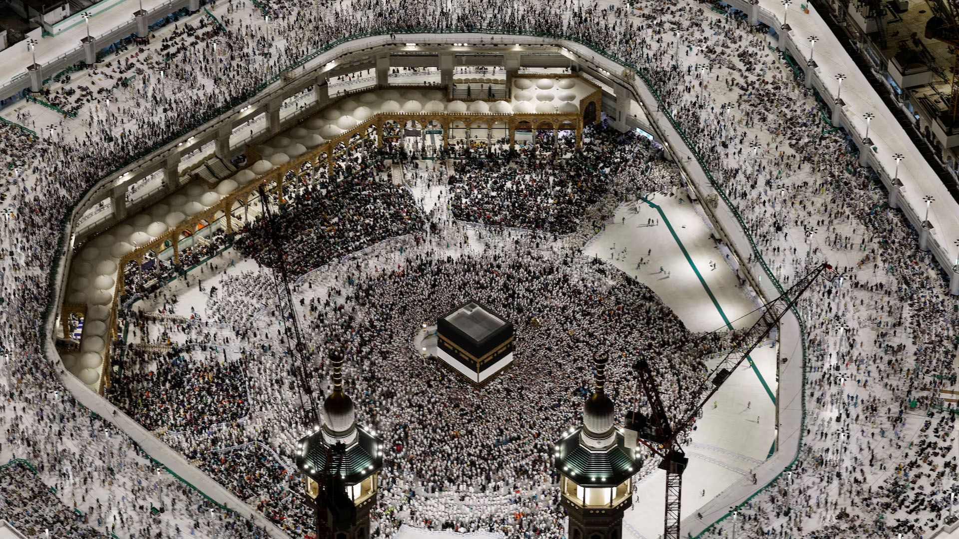 Vue aérienne de la Kaaba avec des pèlerins effectuant le tawaf, de nuit.
